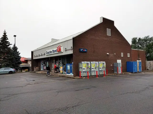 Couche-Tard convenience store, a brick building with red signage and a small parking area