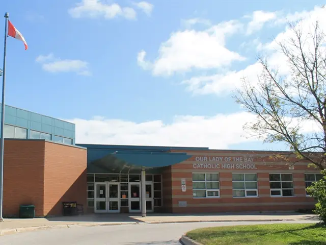 The brick front entrance of a Catholic high school building in Ontario, with a covered doorway and bell tower.