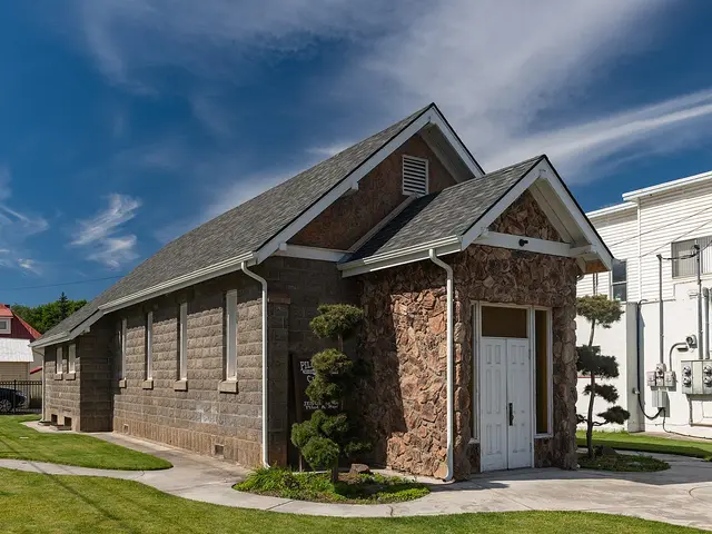 Stone-block Seventh-day Adventist church with twin front gables and a stone archway entrance in Pilot Rock, Oregon.