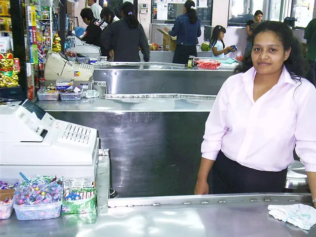 A cashier working at a grocery store checkout register.