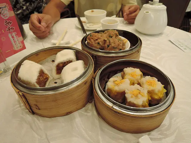 A lunch spread of dim sum dishes and beef rice noodles at a Chinese restaurant.
