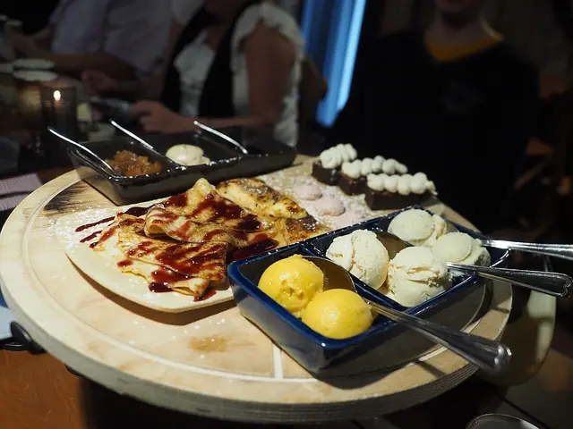 A selection of pancakes, pastries and ice cream served as dessert at a restaurant table.