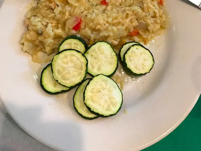 A dinner plate of chicken lemon risotto with zucchini.
