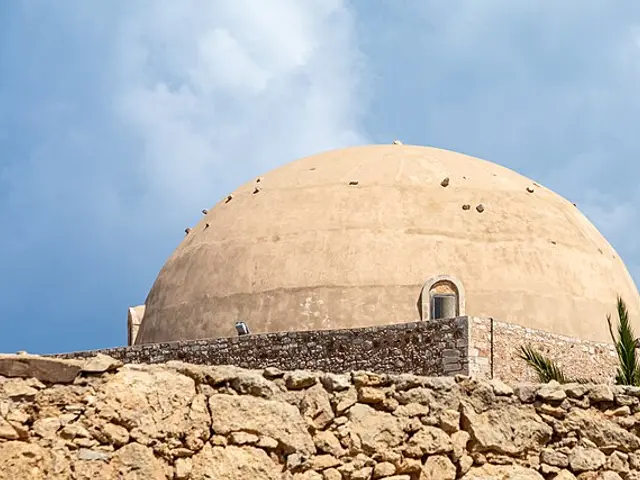 A mosque dome seen over a stone wall