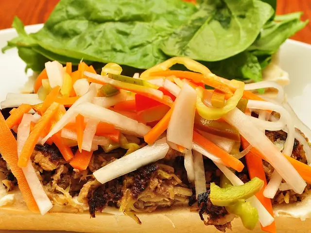 A banh mi sandwich filled with meat and pickled vegetables.