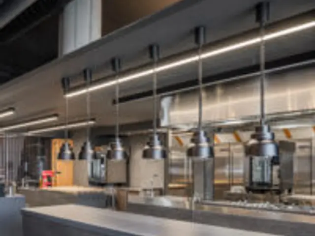 An open kitchen visible from the dining area of a fine dining restaurant.