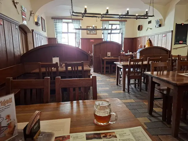 Interior dining room of the U Medvídků restaurant in Prague, Czech Republic, with tables set for guests.