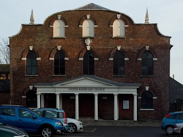 United Reformed Church on Skinner Street, Poole, England, a red brick chapel with a curved parapet, arched windows and a columned entrance porch.