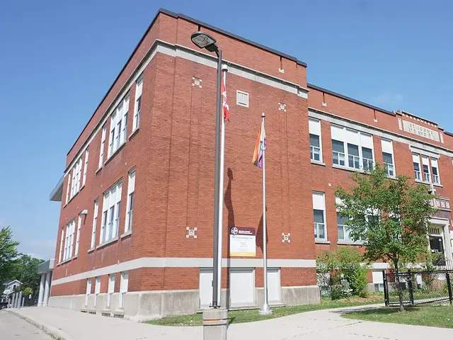 The red-brick facade of St. John's Catholic School in Kitchener, Ontario, with the school's name carved above the entrance.