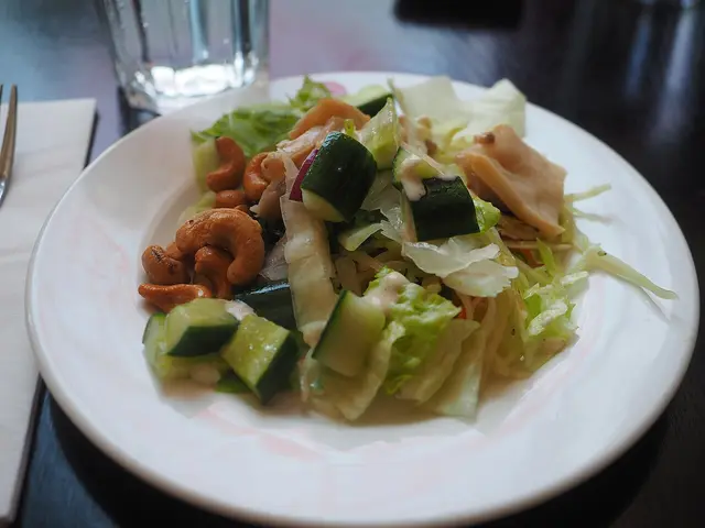 A plate of salad served as a starter at a restaurant table.