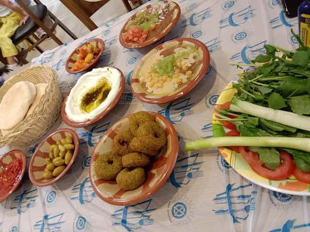A plate of falafel, hummus, and tahini salad with pita bread.