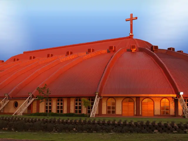 Exterior of the AFM Word and Life worship building, a red-roofed hall with a large rooftop cross, in Boksburg, South Africa.