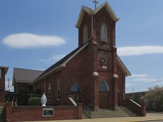 Exterior of Immaculate Conception Church, a brick church building with a tower in Dennison, Ohio.