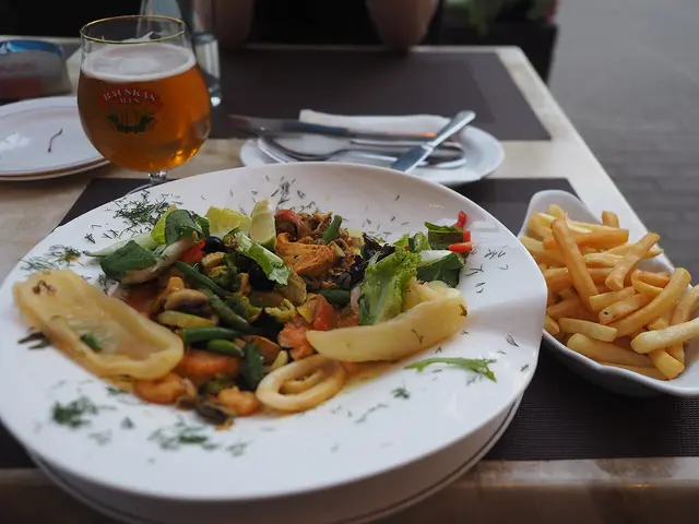 A plate of mixed seafood with fries served at a restaurant table.